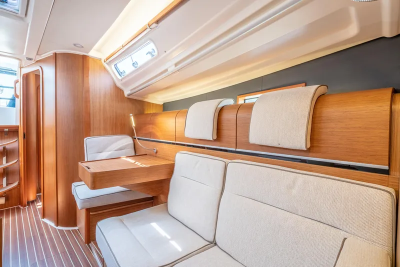 Slide: The Image of Interior of 2016 Dehler 38 sailboat with wooden finishes and beige seating. - 16