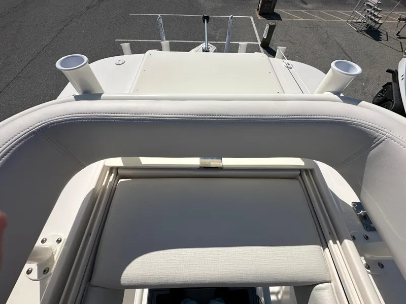 Slide: The Image of 2024 Sea Born FX25 Bay boat interior with white seating and rod holders. - 43