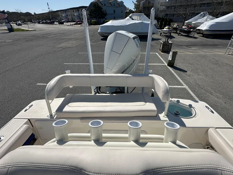 Slide: The Image of 2024 Sea Born FX25 Bay boat with rod holders and outboard motor in a parking lot. - 46
