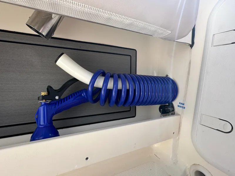 Slide: The Image of 2024 Sea Born FX25 Bay boat with coiled blue hose and spray nozzle. - 47