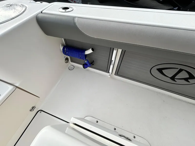 Slide: The Image of 2024 Sea Born LX 22 LE boat interior with storage and coiled blue hose. - 10