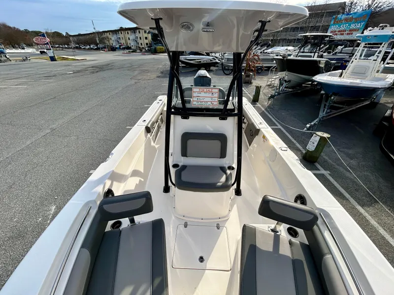 Slide: The Image of 2024 Sea Born LX 22 LE boat interior, featuring seating and console, docked at a marina. - 17