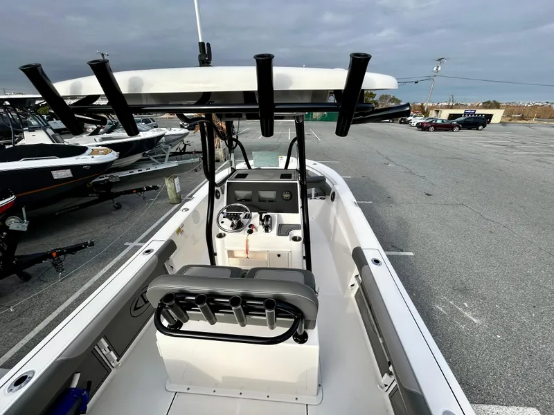 Slide: The Image of 2024 Sea Born LX 22 LE boat interior with console and seating, parked outdoors. - 18