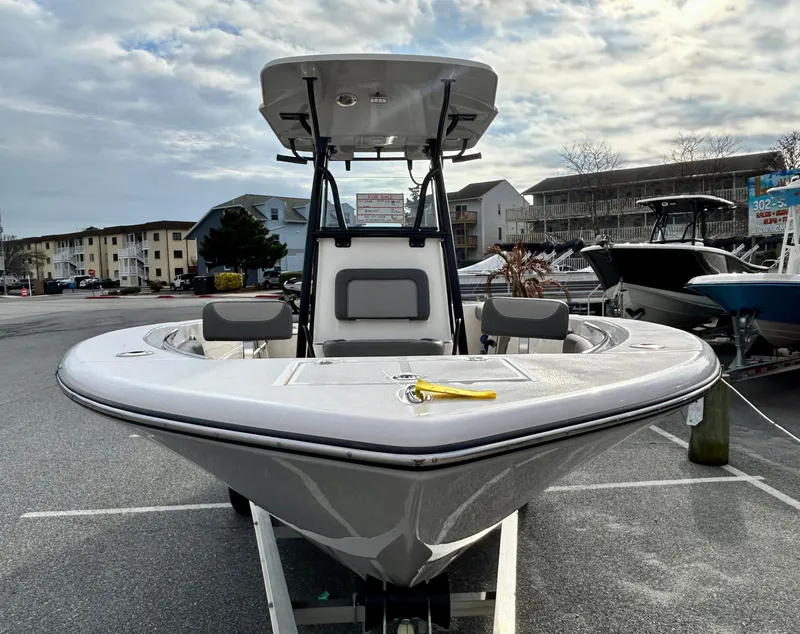 Slide: The Image of 2024 Sea Born LX 22 LE boat in a marina, front view under cloudy sky. - 2