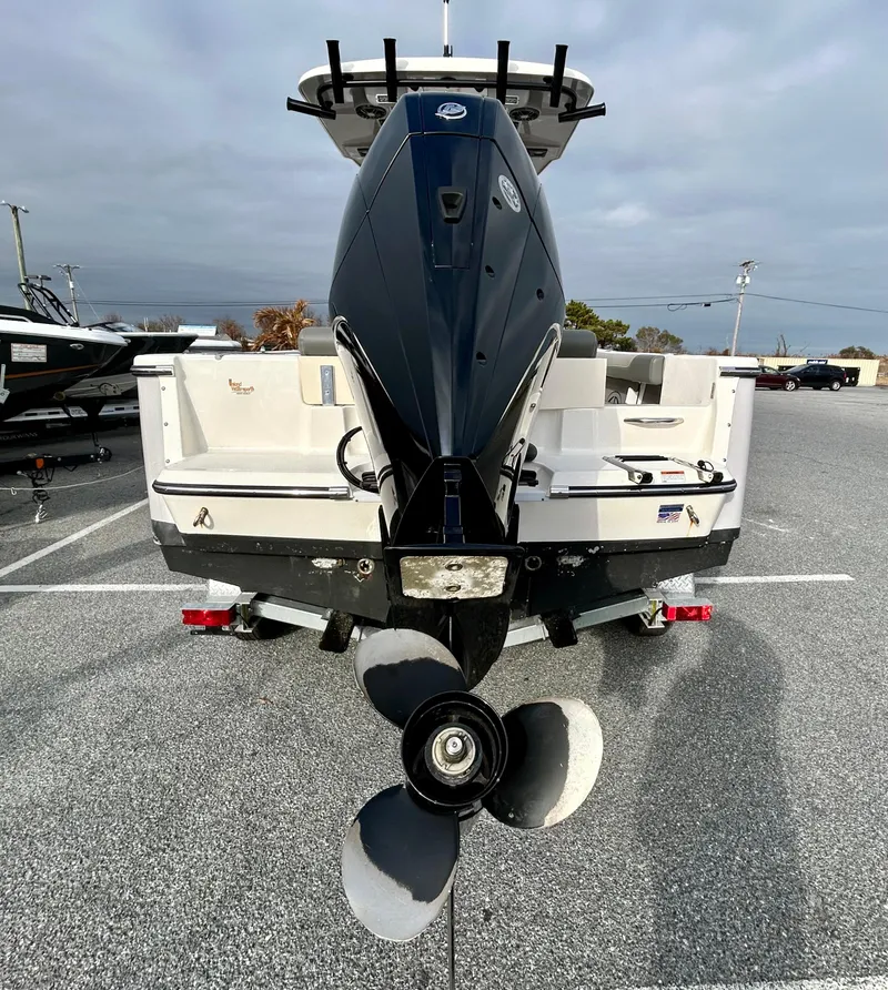Slide: The Image of 2024 Sea Born LX 22 LE boat, rear view with outboard motor in a parking lot. - 22