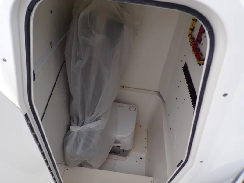 Slide: The Image of 2024 Sea Born SX 239 boat interior storage compartment with covered equipment and portable toilet. - 11