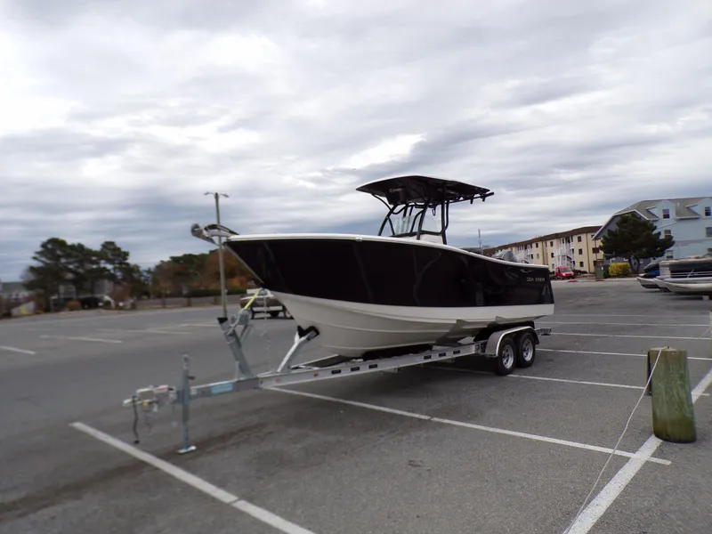 Slide: The Image of 2024 Sea Born SX 239 boat on a trailer in a parking lot. - 4