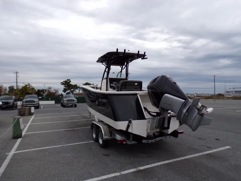 Slide: The Image of 2024 Sea Born SX 239 boat on a trailer in a parking lot. - 6