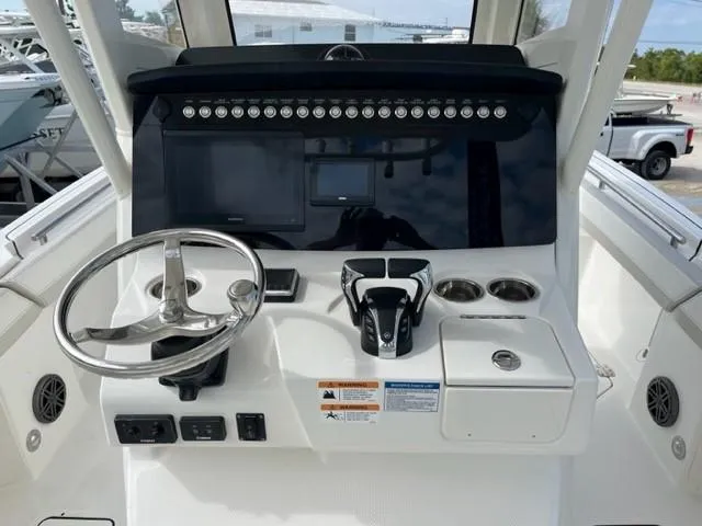 Slide: The Image of 2024 World Cat 260 CC-X boat helm with steering wheel and control panel. - 4