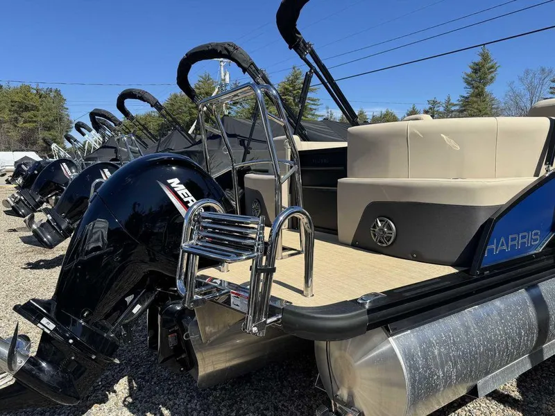 Slide: The Image of 2024 Harris Cruiser 230 pontoon boat with Mercury outboard engine, parked outdoors. - 3