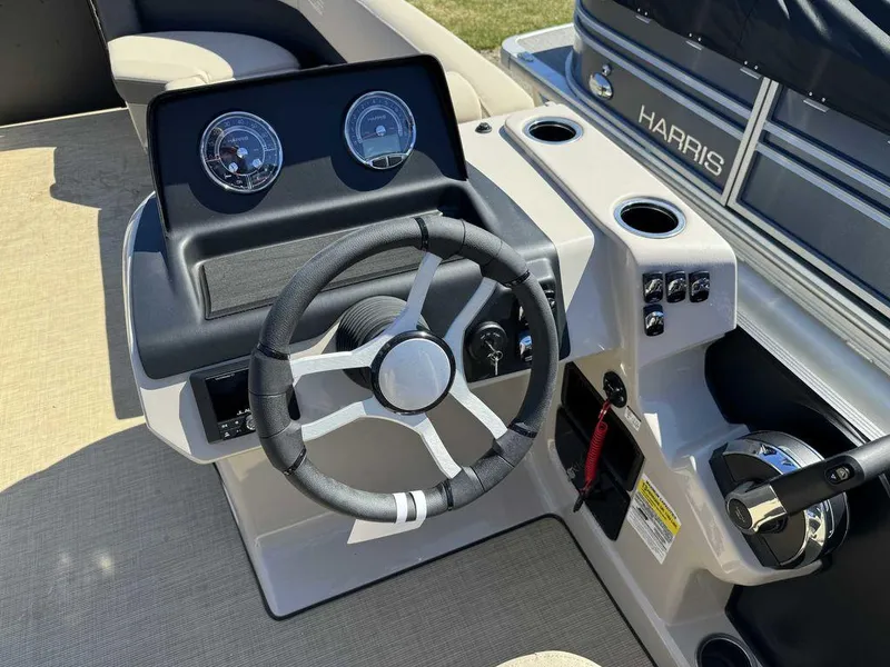 Slide: The Image of 2024 Harris Cruiser 230 boat dashboard with steering wheel and controls. - 7