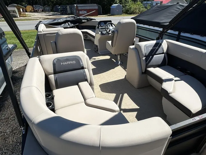 Slide: The Image of 2024 Harris Cruiser 230 boat interior with beige seating and steering console. - 8