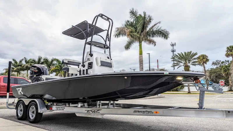 Slide: The Image of 2024 Tidewater 23 TPC Raptor boat on trailer, parked near palm trees. - 2