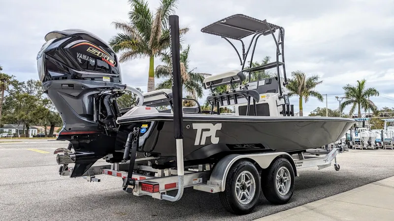 Slide: The Image of 2024 Tidewater 23 TPC Raptor boat on trailer, parked near palm trees. - 6