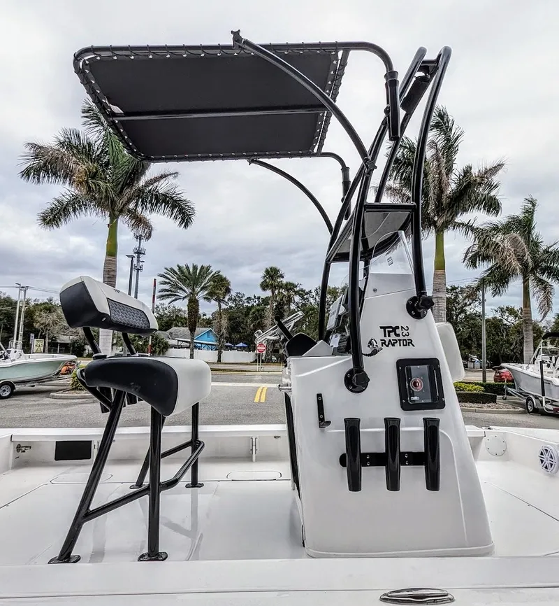 Slide: The Image of 2024 Tidewater 23 TPC Raptor boat with T-top, docked near palm trees. - 8