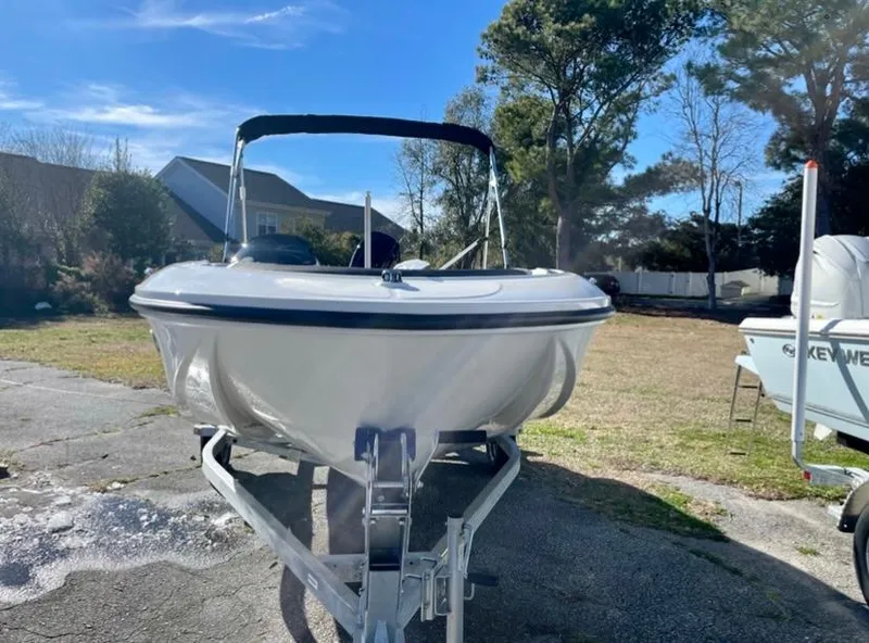 Slide: The Image of 2024 Bayliner Element M15 boat on a trailer in a sunny outdoor setting. - 1