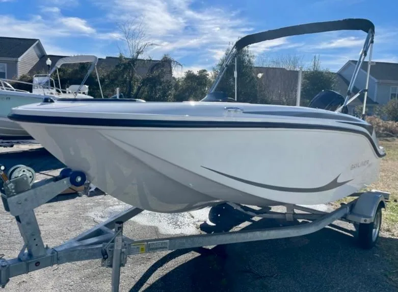 Slide: The Image of 2024 Bayliner Element M15 boat on a trailer under a clear sky. - 2