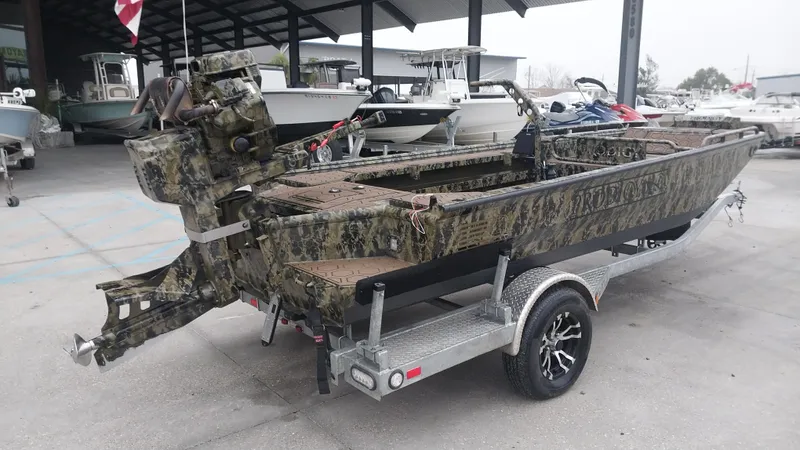 Slide: The Image of 2022 Prodigy 18x60 Marsh Tuff boat on trailer, camo design, parked in marina. - 12