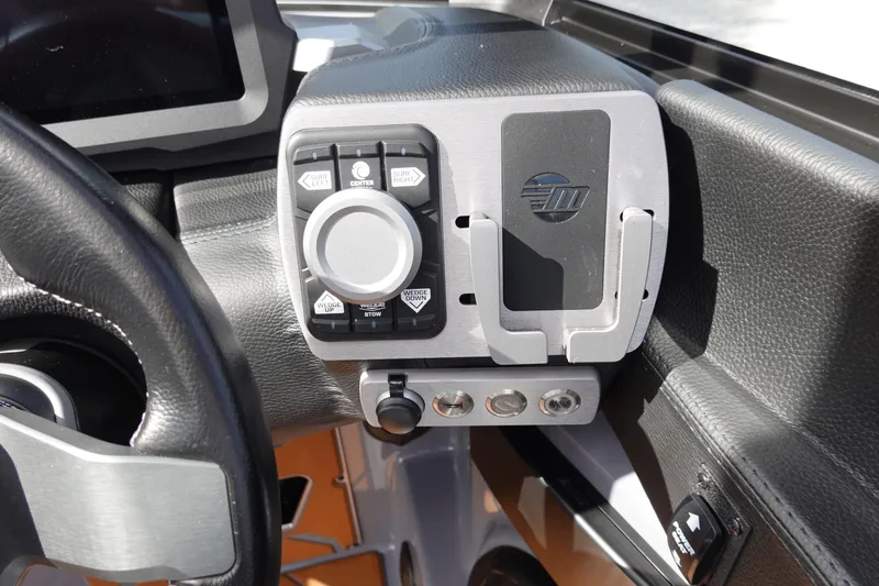 Slide: The Image of 2023 Malibu 25 LSV boat dashboard with control panel and steering wheel. - 16