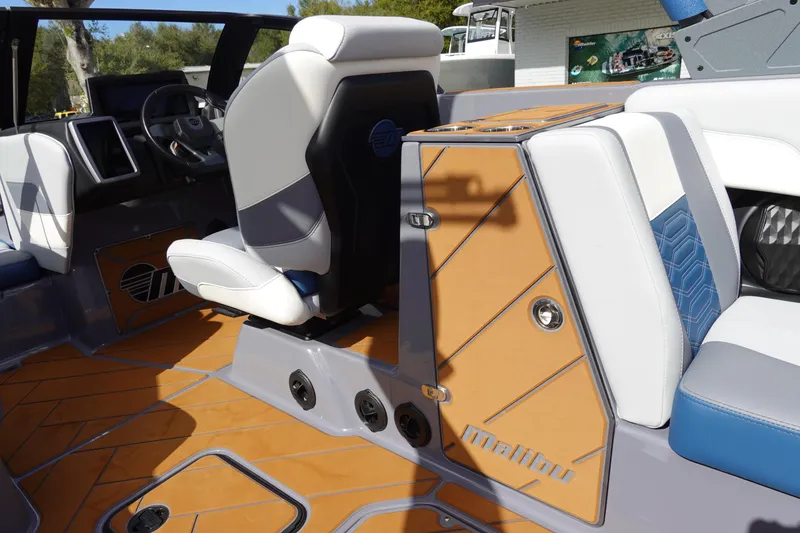 Slide: The Image of 2023 Malibu 25 LSV boat interior with luxurious seating and modern dashboard. - 19