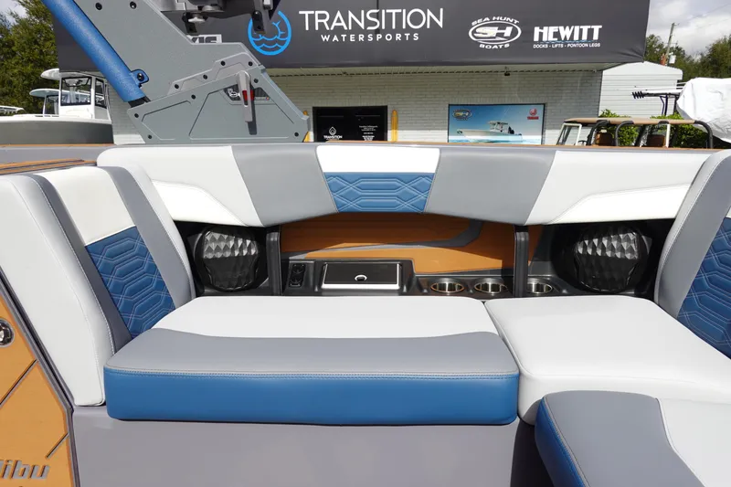 Slide: The Image of 2023 Malibu 25 LSV boat interior with blue and white seating at Transition Watersports. - 25