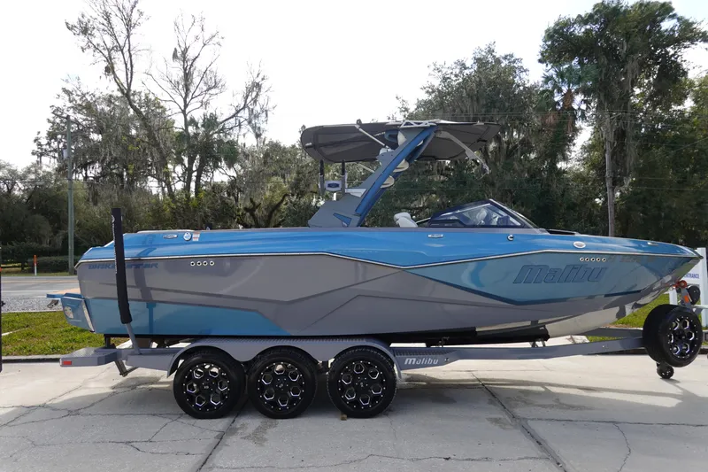 Slide: The Image of 2023 Malibu 25 LSV boat in blue and gray on a trailer. - 3