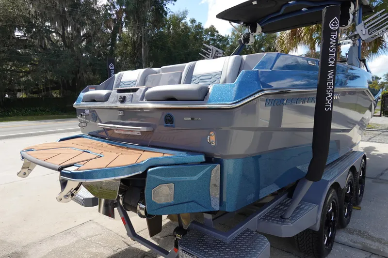 Slide: The Image of 2023 Malibu 25 LSV boat with blue exterior and teak swim platform. - 4