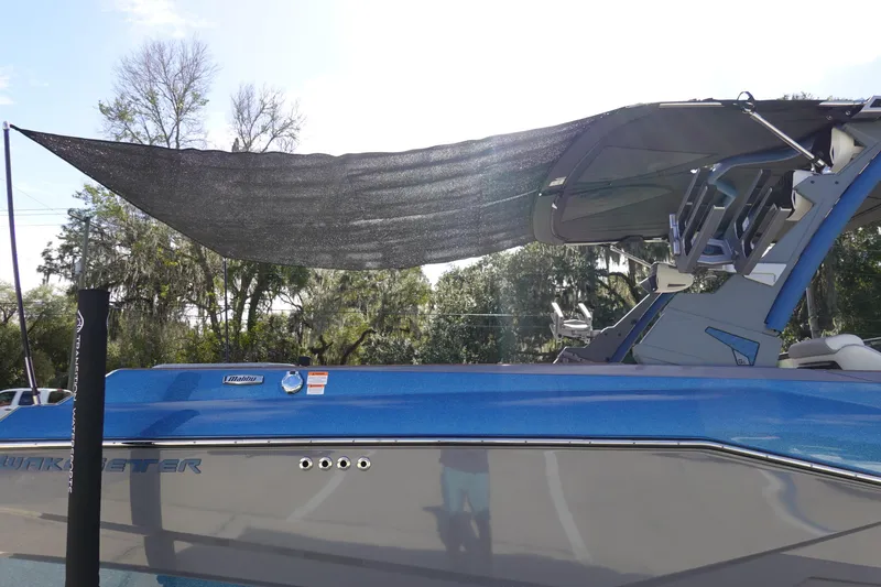 Slide: The Image of 2023 Malibu 25 LSV boat with sunshade, blue and gray exterior. - 48