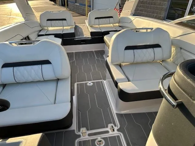 Slide: The Image of 2021 Regal LS6 boat interior with white and black seating, gray flooring, and modern design. - 14