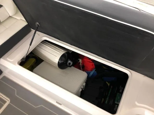 Slide: The Image of Storage compartment of a 2021 Regal LS6 boat with various items inside. - 15