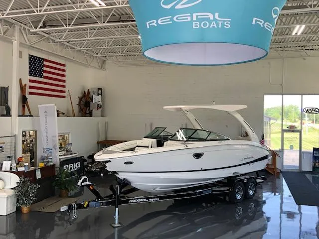 Slide: The Image of 2021 Regal LS6 boat displayed in showroom with American flag and Regal Boats banner. - 3