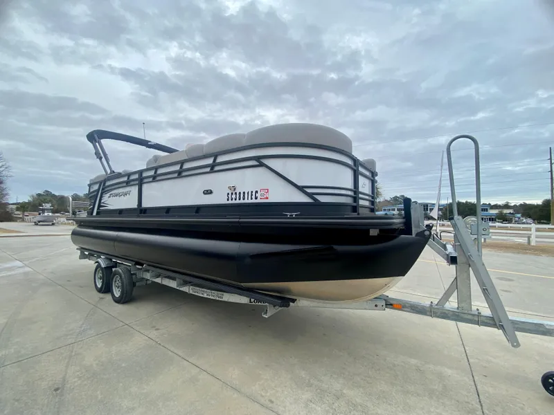 Slide: The Image of 2023 Starcraft SLS 3 pontoon boat on a trailer under cloudy skies. - 1