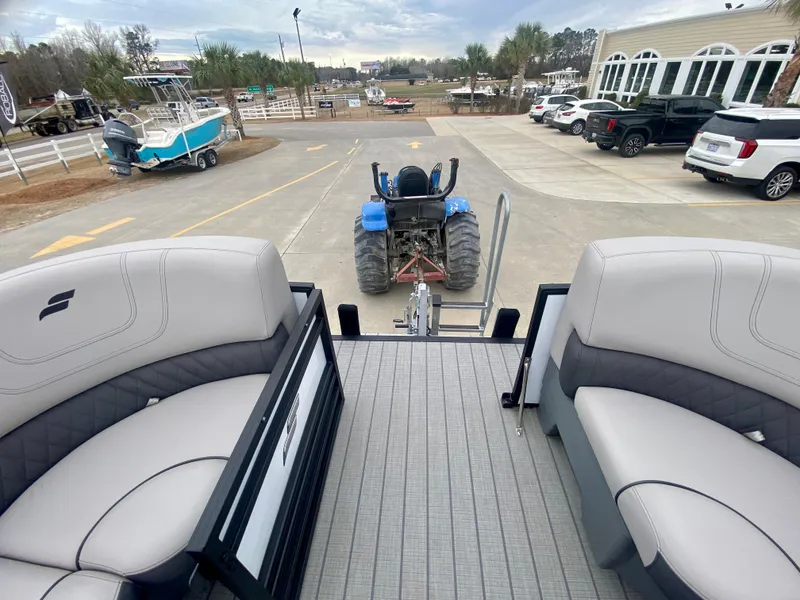 Slide: The Image of 2023 Starcraft SLS 3 pontoon boat being towed by a blue tractor. - 18