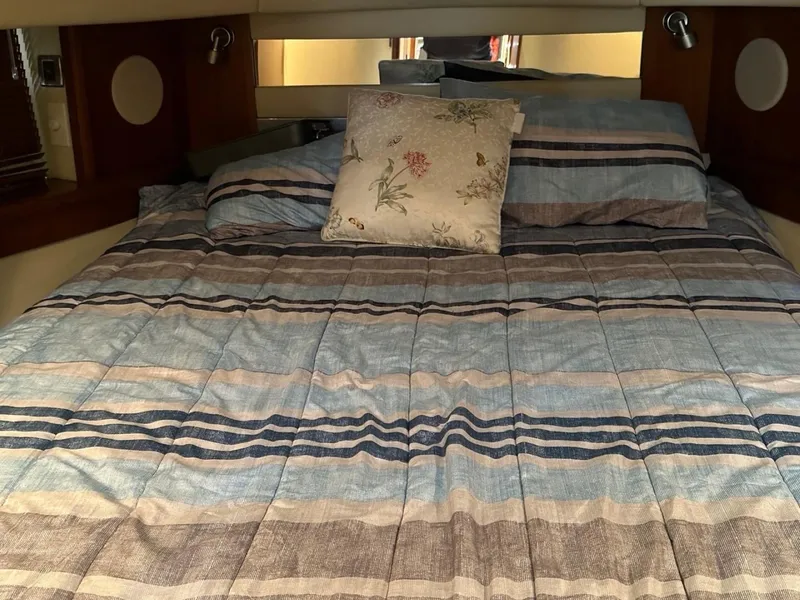 Slide: The Image of Cozy bedroom in 2006 Sea Ray 48 Sundancer yacht with striped bedding and floral pillow. - 16