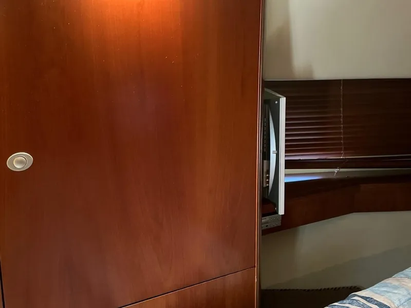 Slide: The Image of Interior of 2006 Sea Ray 48 Sundancer with wooden cabinetry and built-in TV. - 17