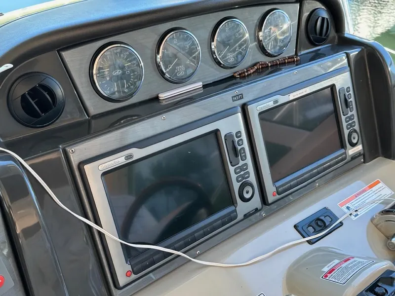 Slide: The Image of Dashboard of a 2006 Sea Ray 48 Sundancer with navigation screens and gauges. - 4
