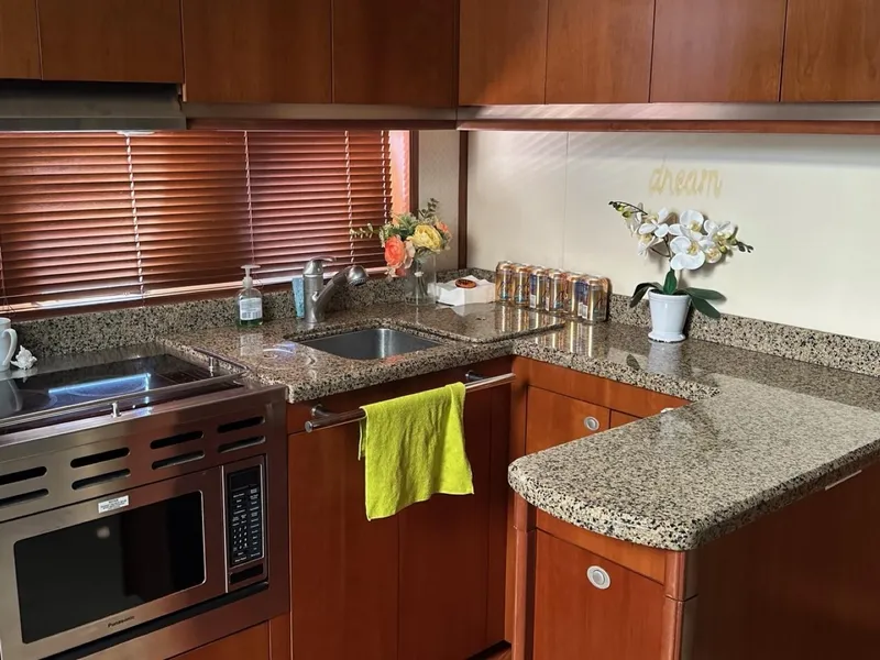 Slide: The Image of Luxurious kitchen in 2006 Sea Ray 48 Sundancer yacht with granite countertops and wooden cabinets. - 8