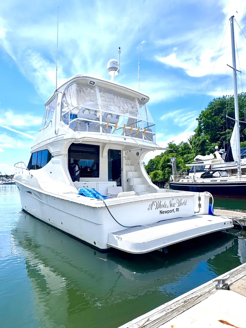 Slide: The Image of 2006 Silverton 50 Convertible yacht docked in a marina under a clear blue sky. - 3