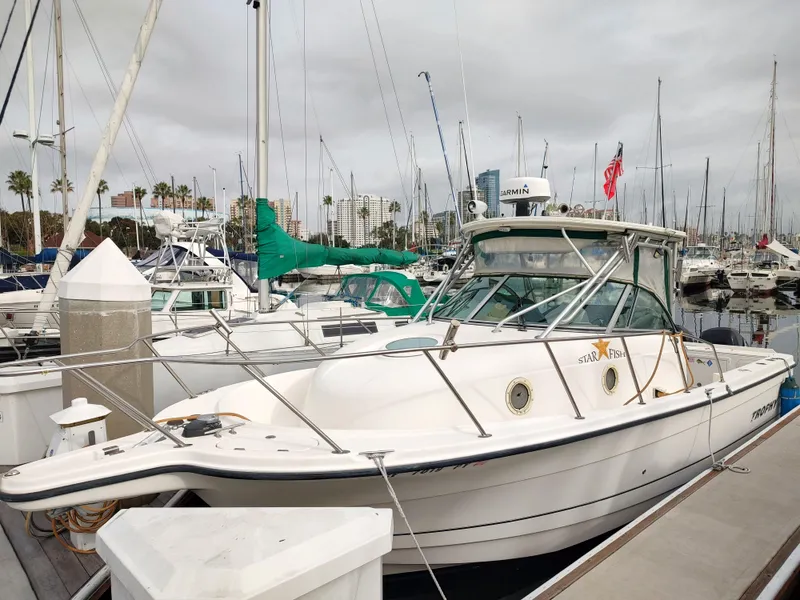 The Image of 2003 Trophy 2902 Walkaround boat docked at a marina with other boats. - 0