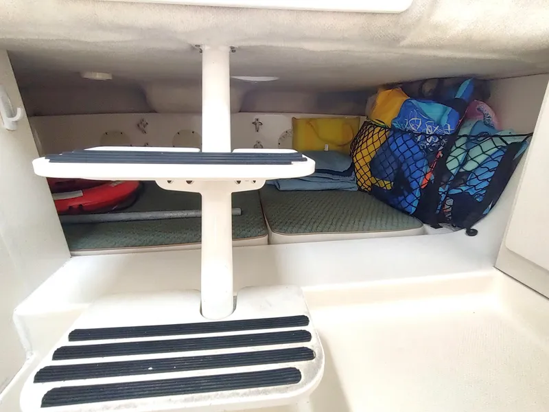 Slide: The Image of 2003 Trophy 2902 Walkaround cabin storage area with steps and organized gear. - 11