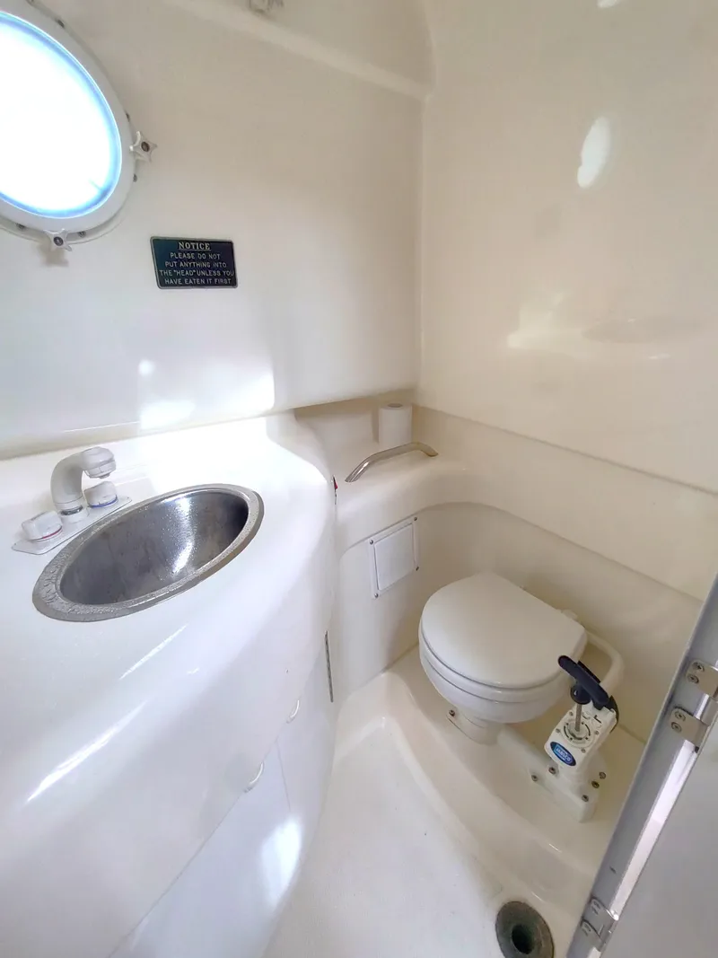Slide: The Image of 2003 Trophy 2902 Walkaround boat bathroom with sink and toilet. - 12