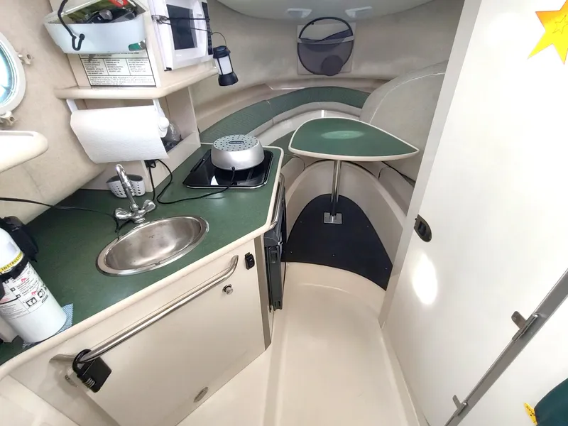 Slide: The Image of 2003 Trophy 2902 Walkaround boat interior with kitchenette and seating area. - 8