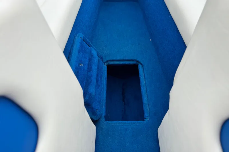 Slide: The Image of Interior of 1994 Howard 22 Bowrider boat with blue carpeted storage compartment. - 13