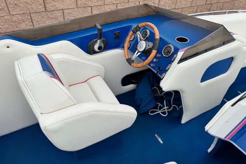 Slide: The Image of 1994 Howard 22 Bowrider boat interior with blue dashboard and white seating. - 21
