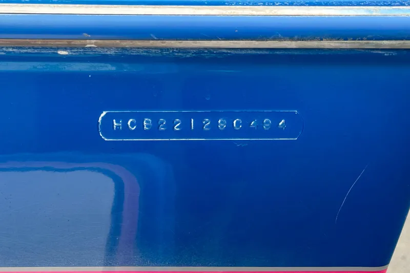 Slide: The Image of Blue 1994 Howard 22 Bowrider boat with visible hull identification number. - 23