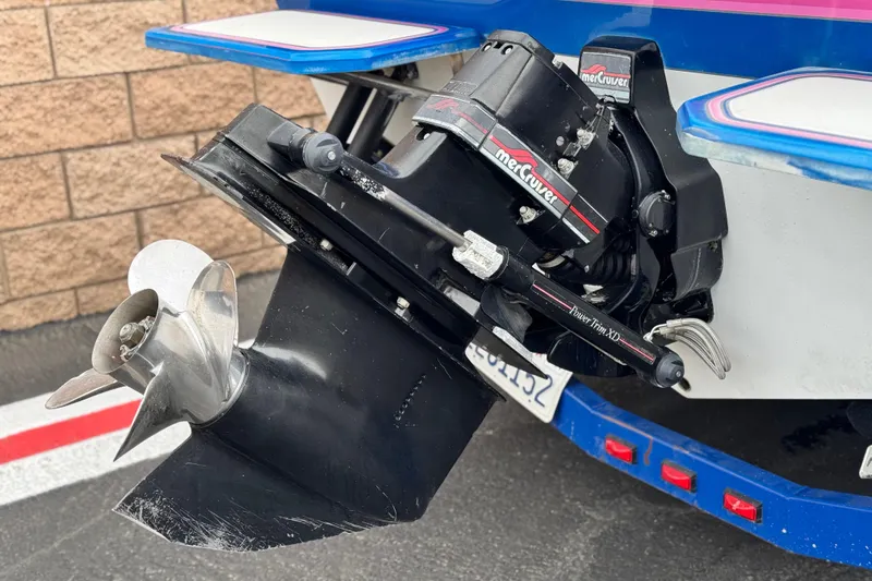 Slide: The Image of 1994 Howard 22 Bowrider boat with MerCruiser outdrive and propeller, parked near a brick wall. - 6