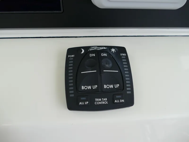 Slide: The Image of Bennett trim tab control on 2024 Pioneer 270 Pelagic boat dashboard. - 16