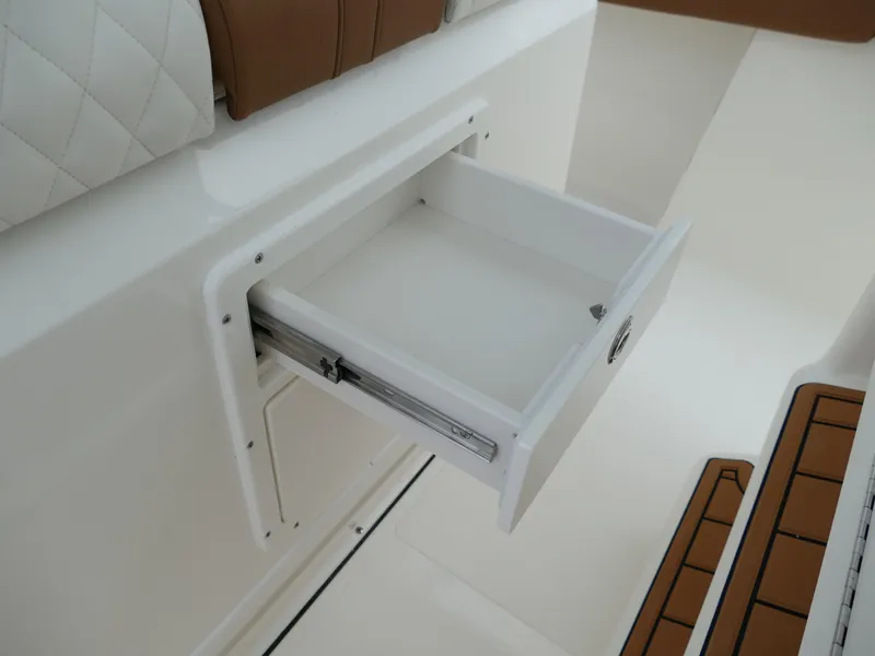 Slide: The Image of Open storage drawer on 2024 Pioneer 270 Pelagic boat with white and brown interior. - 29