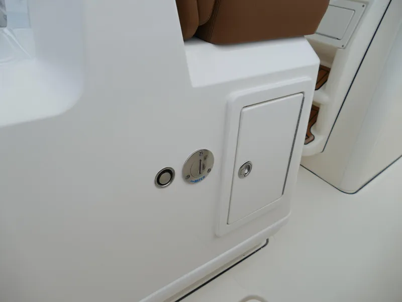 Slide: The Image of Close-up of 2024 Pioneer 270 Pelagic boat's white storage compartment and control panel. - 32