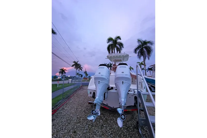 Slide: The Image of 2024 Pioneer 270 Pelagic boat with dual engines, set against a tropical sunset backdrop. - 75